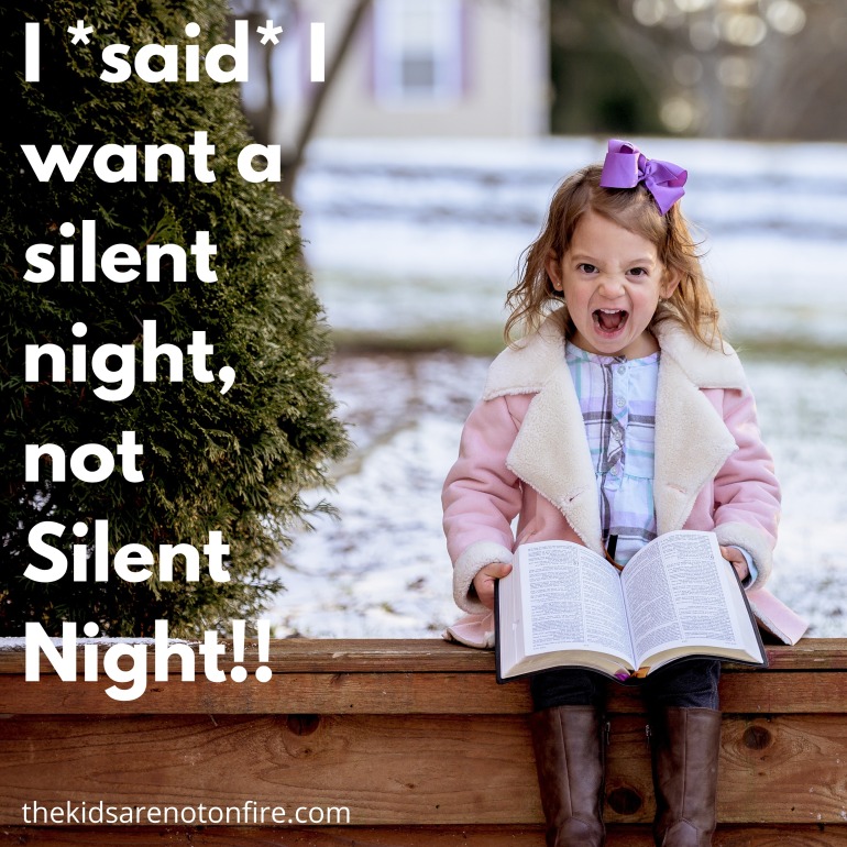 Young girl sits on a bench in the snow, holding a book with her mouth wide open and a frustrated expression.  Text reads, "I said I want a silent night, not Silent Night!!"